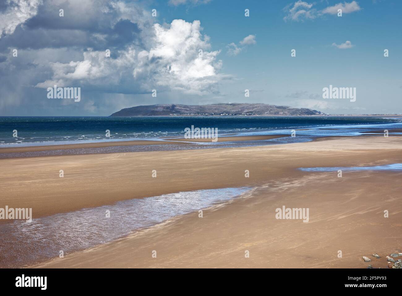 Penmaenmawr Beach, in der Nähe der Stadt Penmaenmawr in Nord-Wales, ist ein langer Sandstrand neben der Menai Straits. Stockfoto
