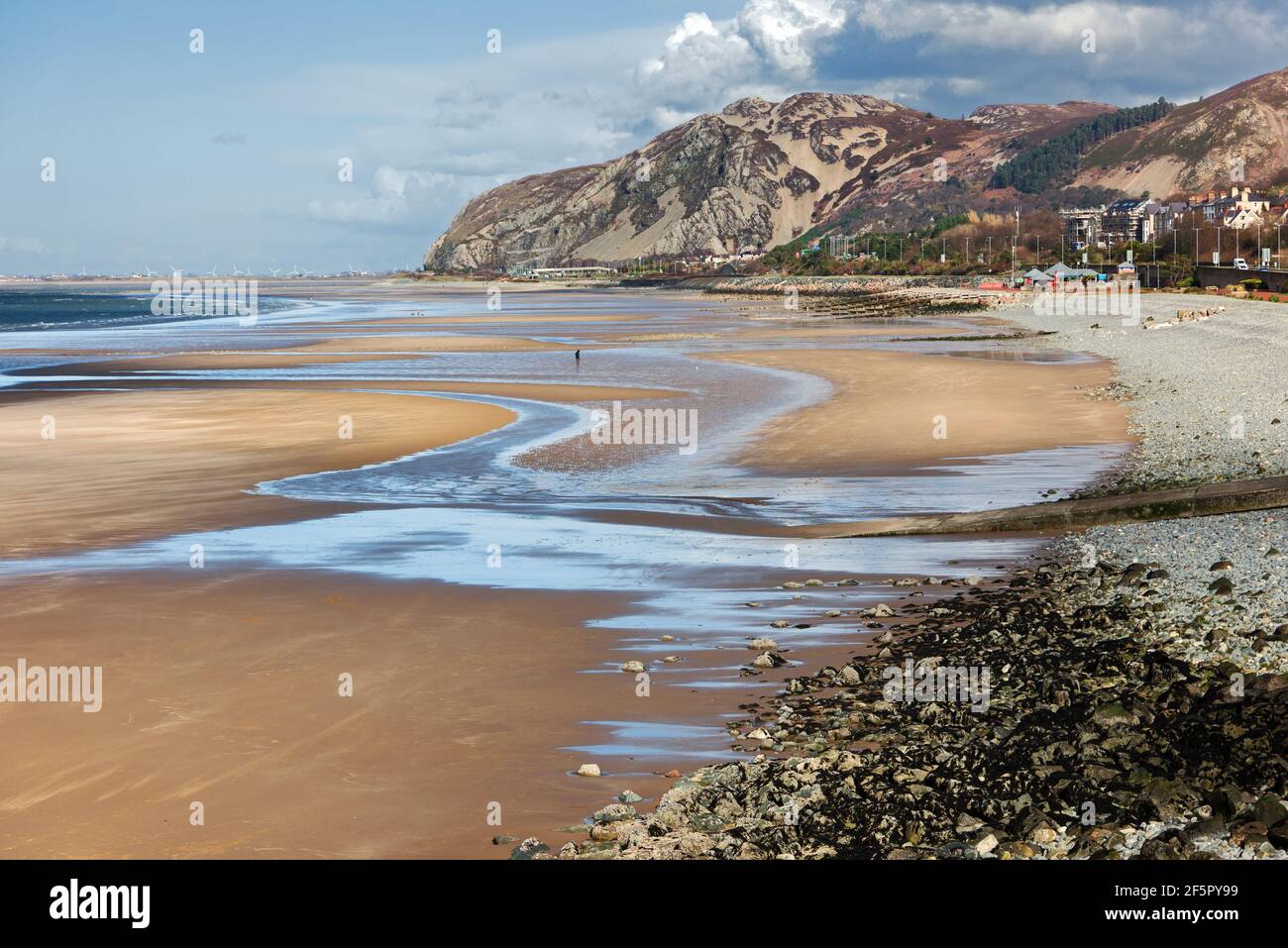 Penmaenmawr Beach, in der Nähe der Stadt Penmaenmawr in Nord-Wales, ist ein langer Sandstrand neben der Menai Straits. Stockfoto