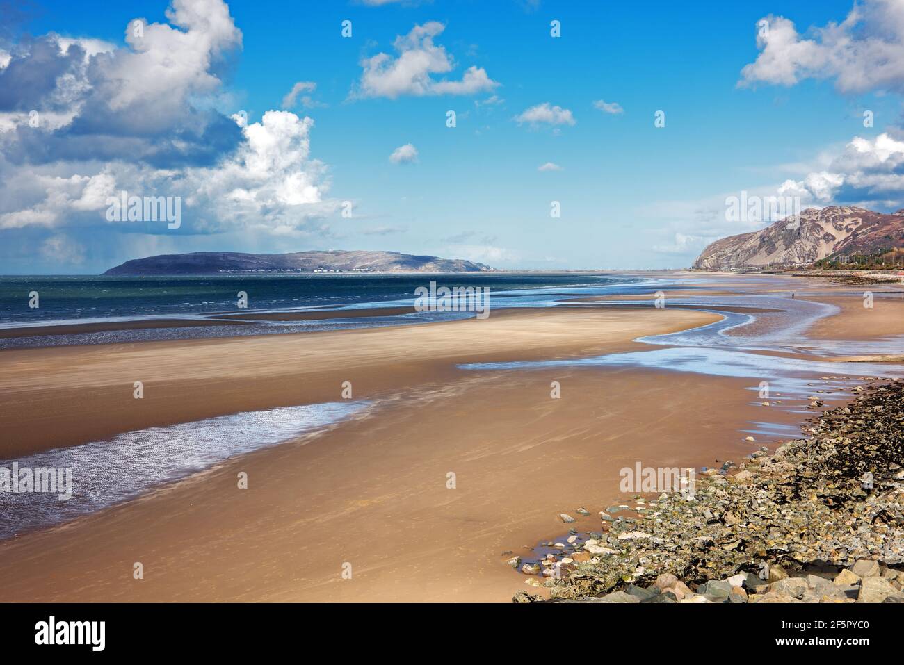 Penmaenmawr Beach, in der Nähe der Stadt Penmaenmawr in Nord-Wales, ist ein langer Sandstrand neben der Menai Straits. Stockfoto
