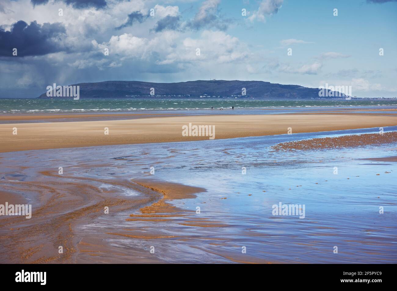 Penmaenmawr Beach, in der Nähe der Stadt Penmaenmawr in Nord-Wales, ist ein langer Sandstrand neben der Menai Straits. Stockfoto
