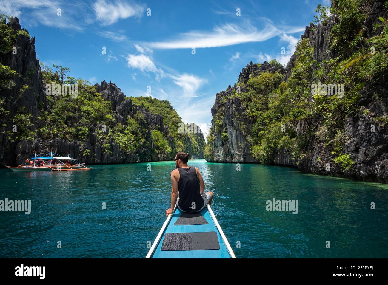 El Nido, Palawan, Philippinen, Reisende, die auf dem Bootsdeck sitzen und an einem sonnigen Tag die natürlichen Sehenswürdigkeiten rund um El Nido erkunden. Stockfoto