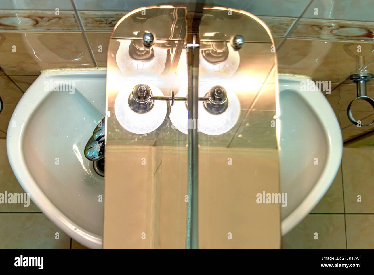 Ein Spiegel mit Regal über Waschbecken und unter Lampe in einem Badezimmer  Stockfotografie - Alamy