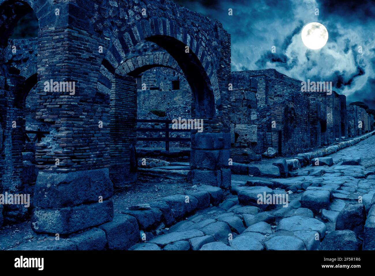 Pompeji bei Nacht, Italien. Mystische apokalyptische Ansicht der zerstörten Häuser der alten Stadt im Vollmond. Gruselige dunkle Szene für Halloween-Thema. Konzept von h Stockfoto