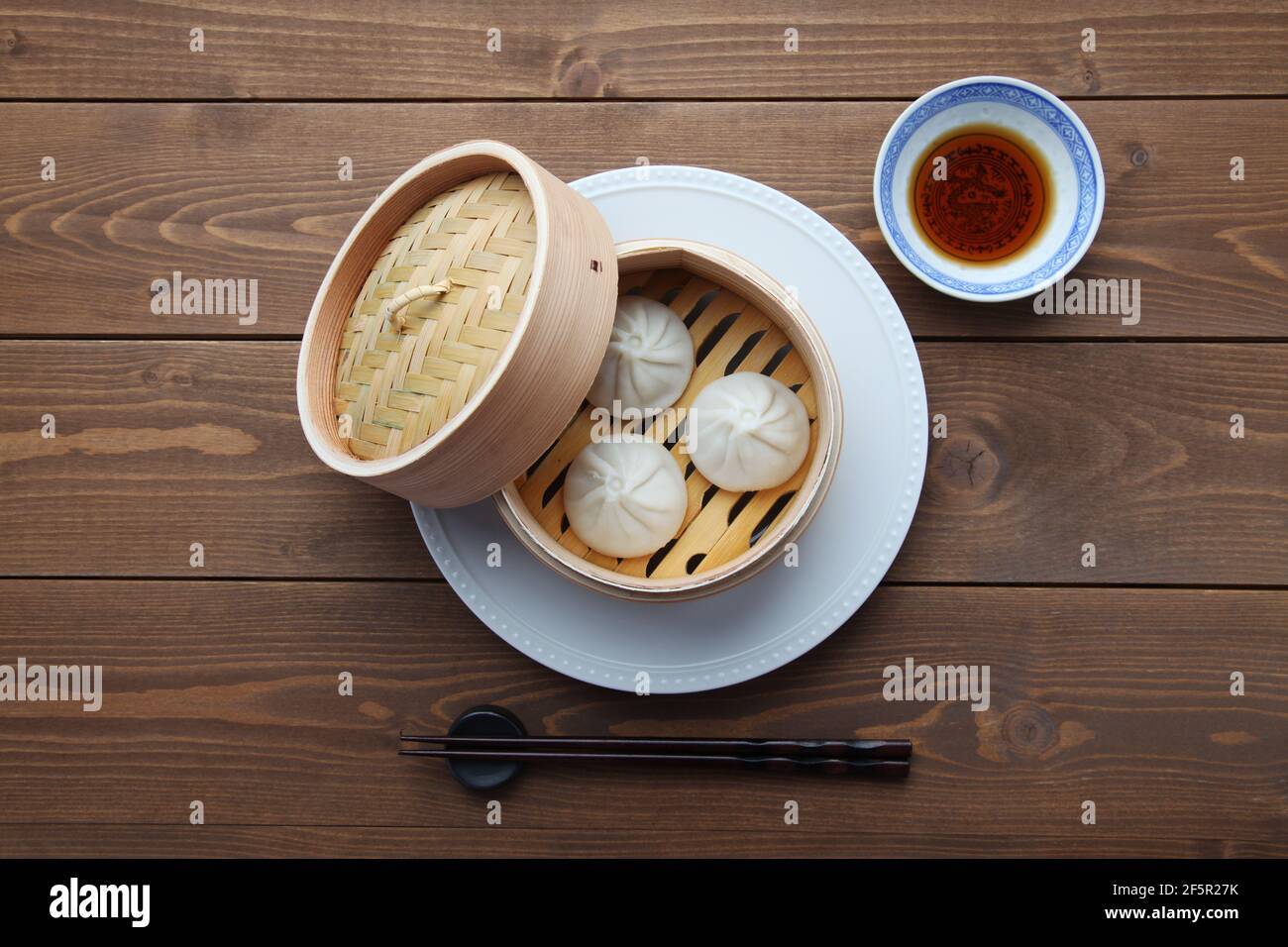 Xiaolongbao chinesisches gedünstetes Brötchen mantou Knödel auf Holztisch Stockfoto