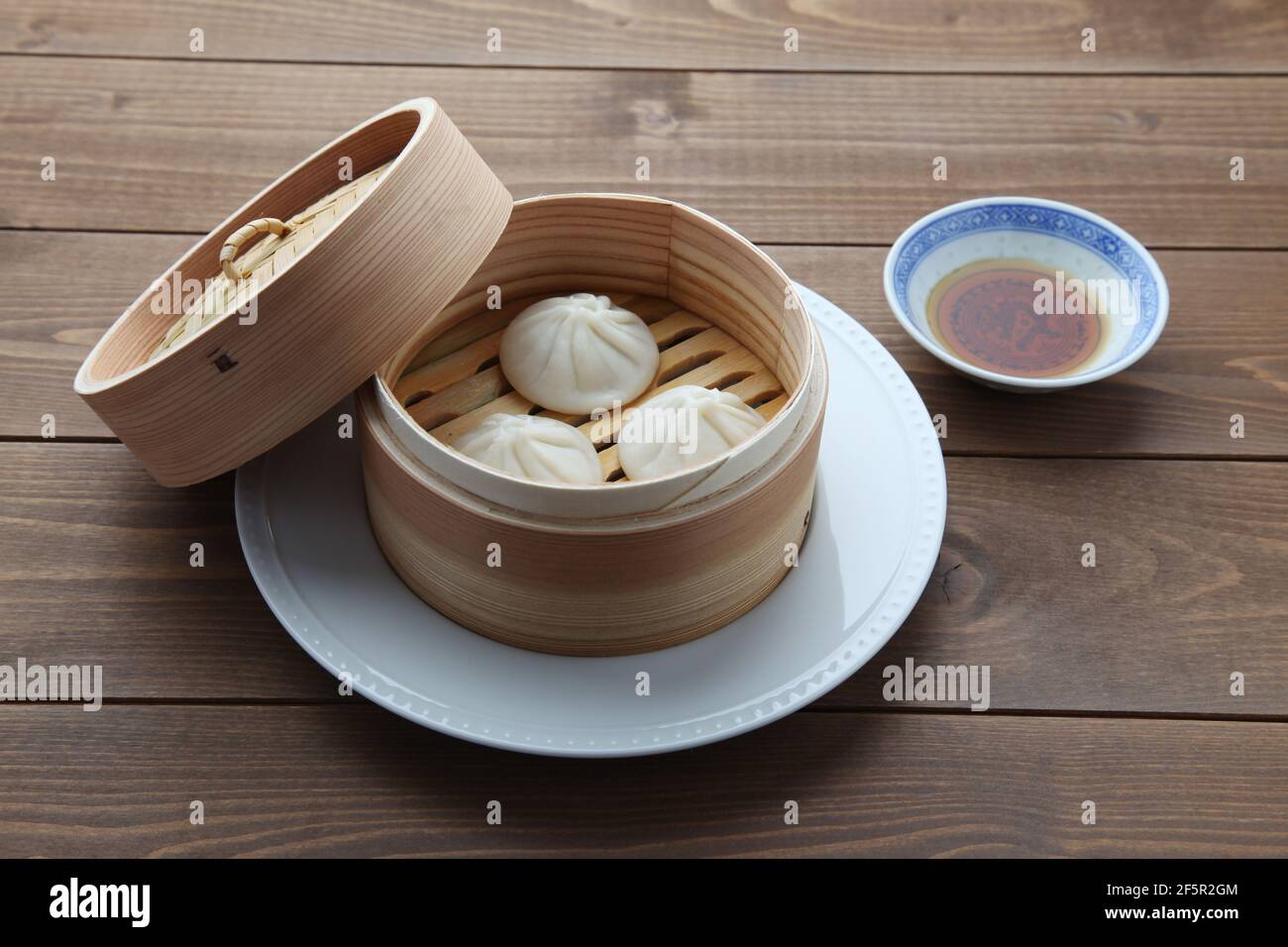 Xiaolongbao chinesisches gedünstetes Brötchen mantou Knödel auf Holztisch Stockfoto