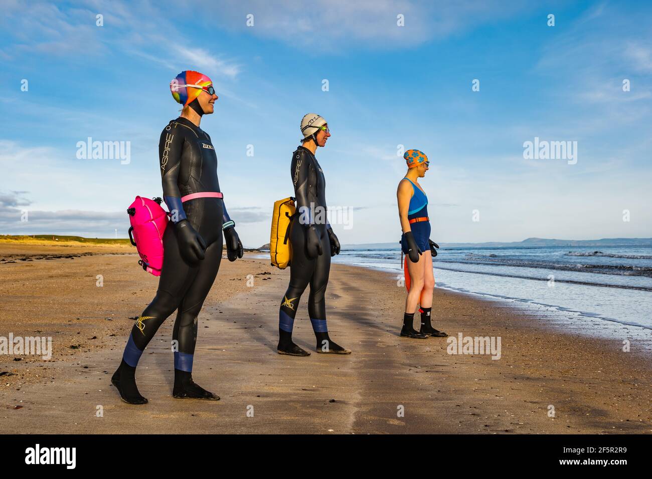 Wildwasser- oder Freiwasser-Schwimmerinnen in Neoprenanzügen mit Schwimmhilfe schwimmt am Strand in West Bay, North Berwick, East Lothian, Schottland, Großbritannien Stockfoto