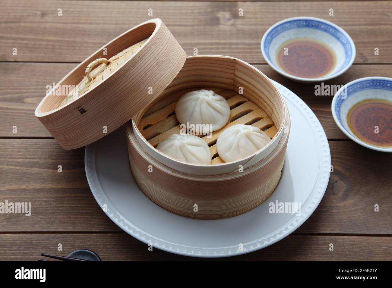 Xiaolongbao chinesisches gedünstetes Brötchen mantou Knödel auf Holztisch Stockfoto