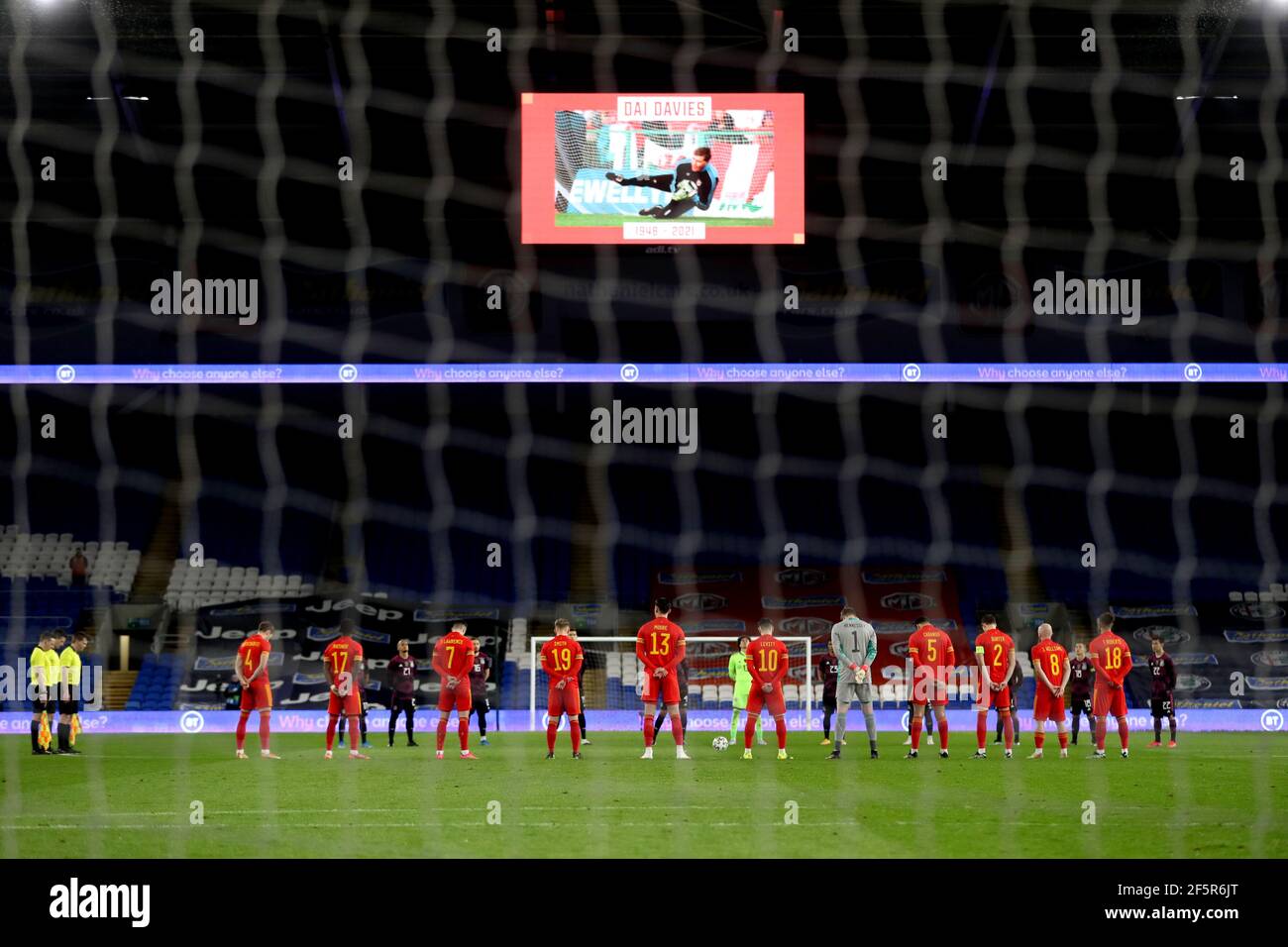 Spieler und vierte Beamte beobachten eine Schweigeminute in Erinnerung an den ehemaligen Wales-Torhüter Dai Davies vor dem internationalen Freundschaftsspieler im Cardiff City Stadium, Cardiff. Bilddatum: Samstag, 27. März 2021. Stockfoto