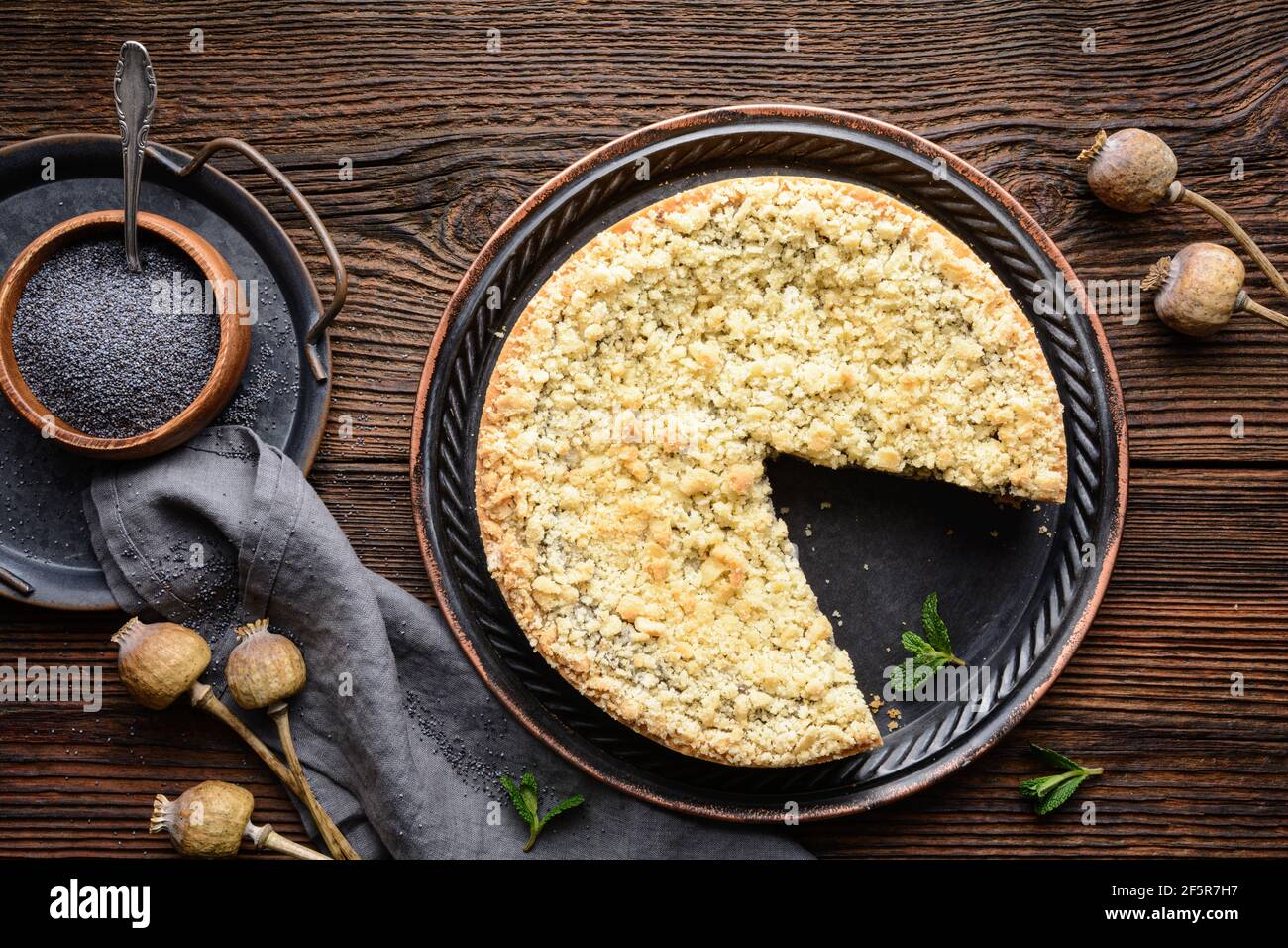 Mohnkuchen, deutscher Mohnkuchen mit knusprigem Streusel auf rustikalem Holzhintergrund Stockfoto
