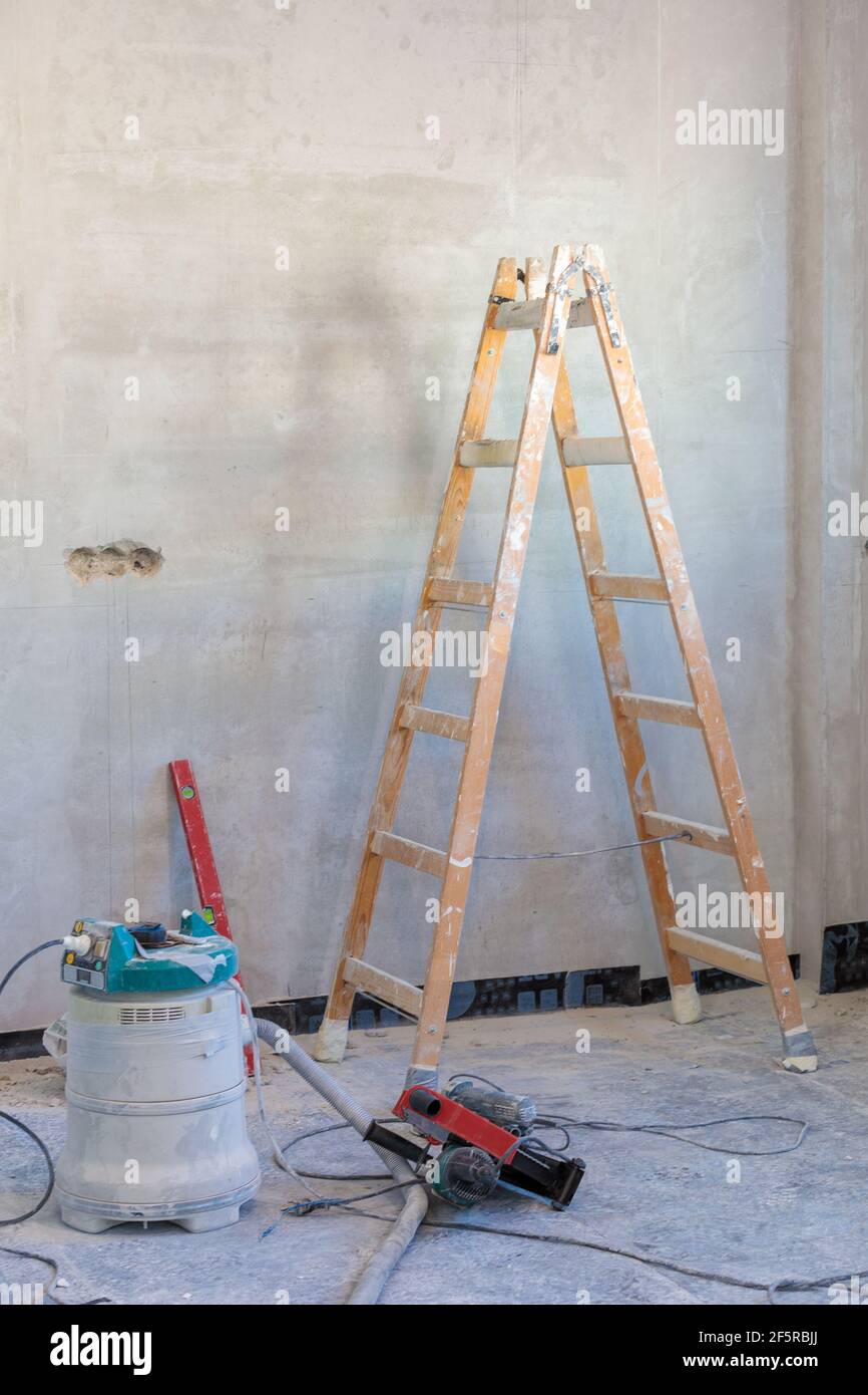 Ein Zimmer mit einer Stube und einem Werkzeug für Reparaturen im Prozess der Fertigstellung der Wohnung. Stockfoto