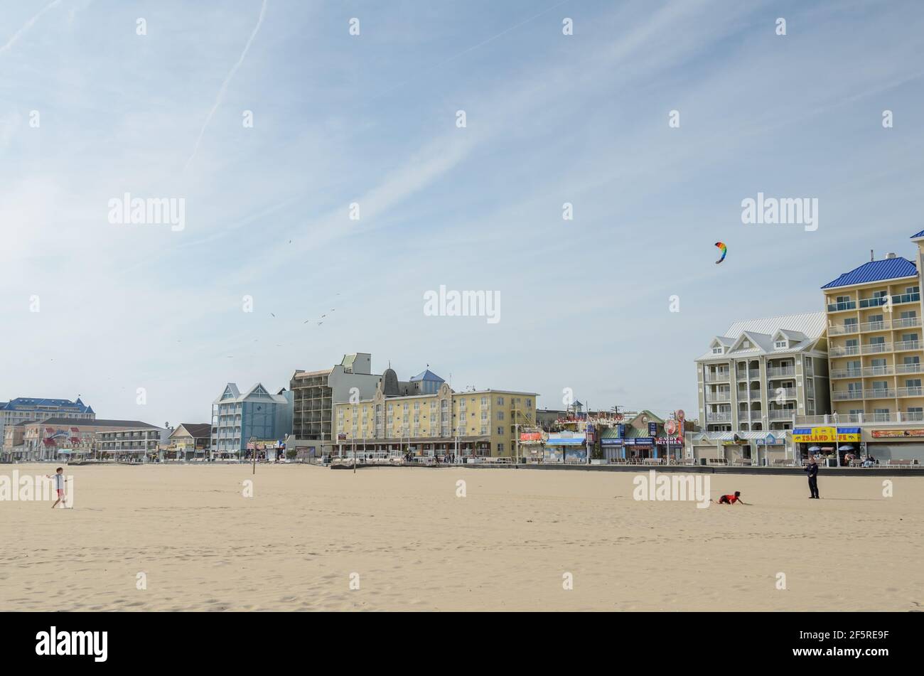 Menschen, die in der Nebensaison in Ocean City, Maryland, USA, am leeren Strand Drachen steigen lassen Stockfoto