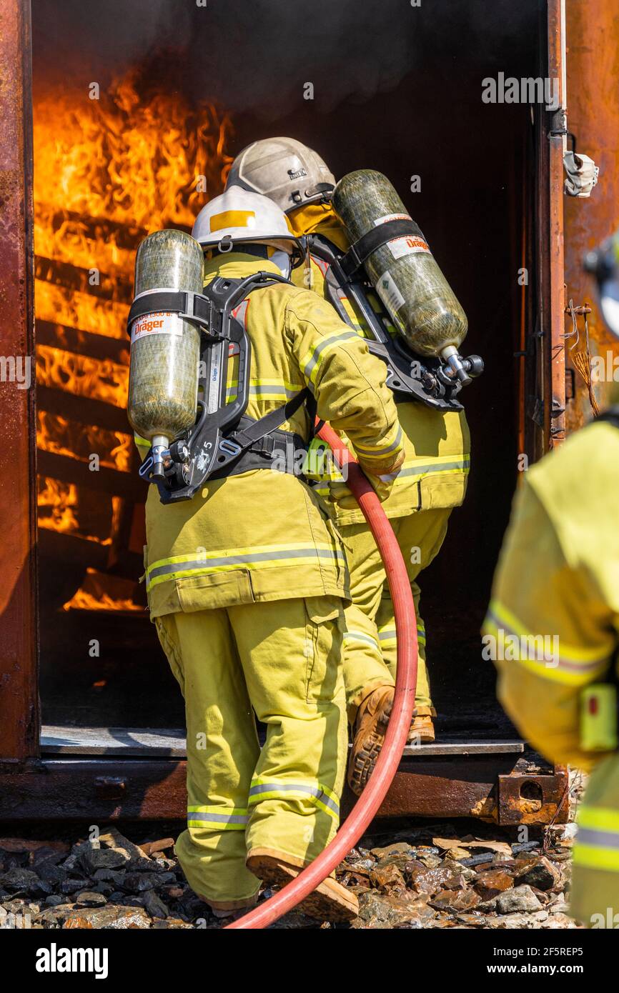 Das Notfallteam der Mine in Schutzkleidung und Atemschutzgeräten übt Brandbekämpfung und Notfallübungen am Feuerplatz aus. Stockfoto