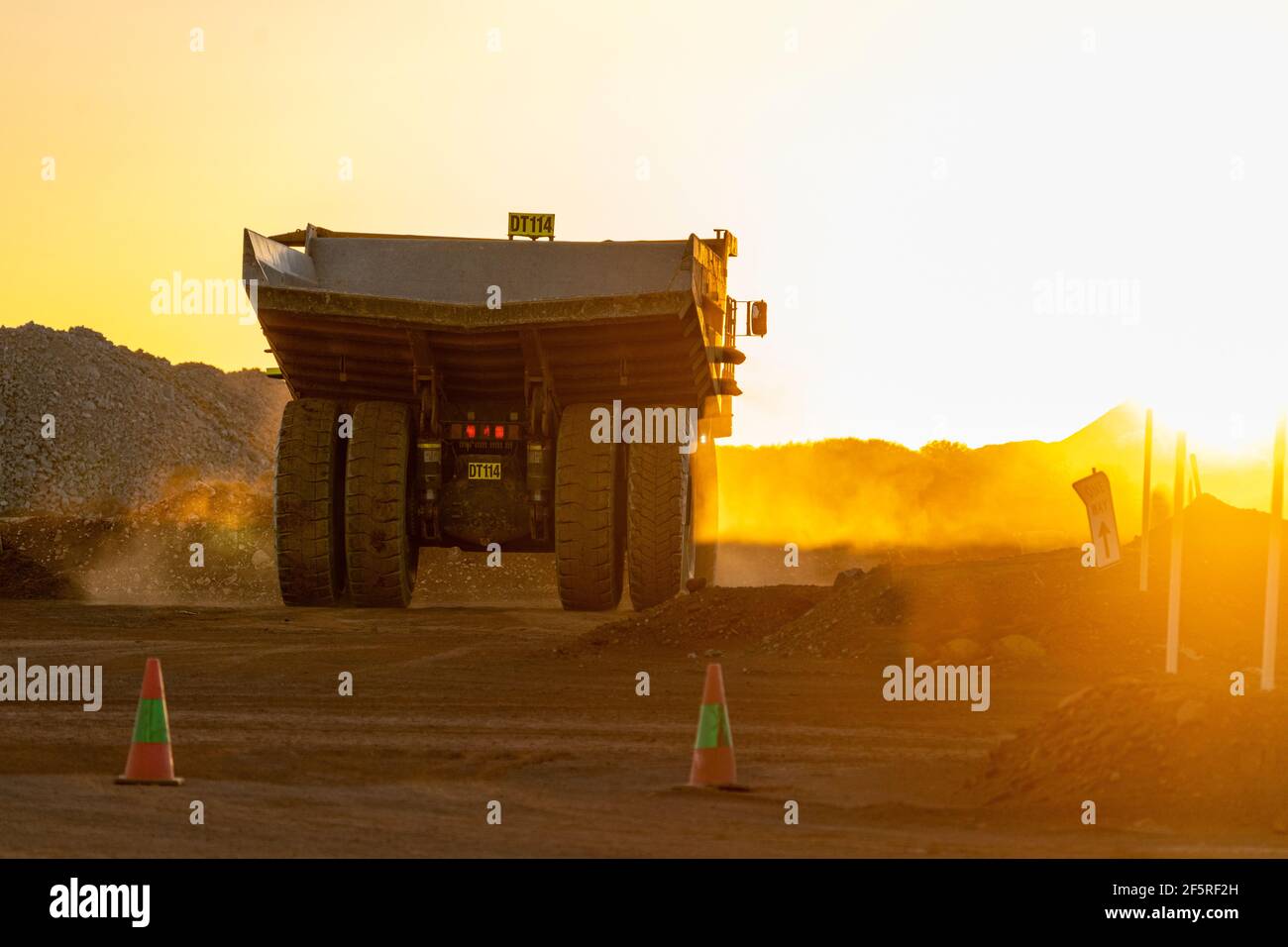 Muldenkipper, der bei Sonnenuntergang auf der Haul Road im Tagebaugebiet fährt. Stockfoto