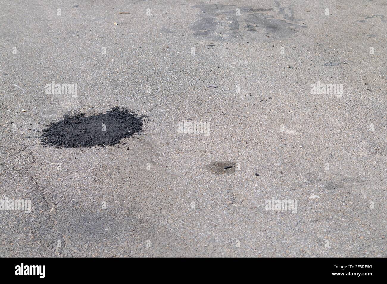 Schlechte oder schlechte Straßenreparaturen, Straßenflicken auf Schlaglöchern beschädigte Straßenbeläge. Stockfoto