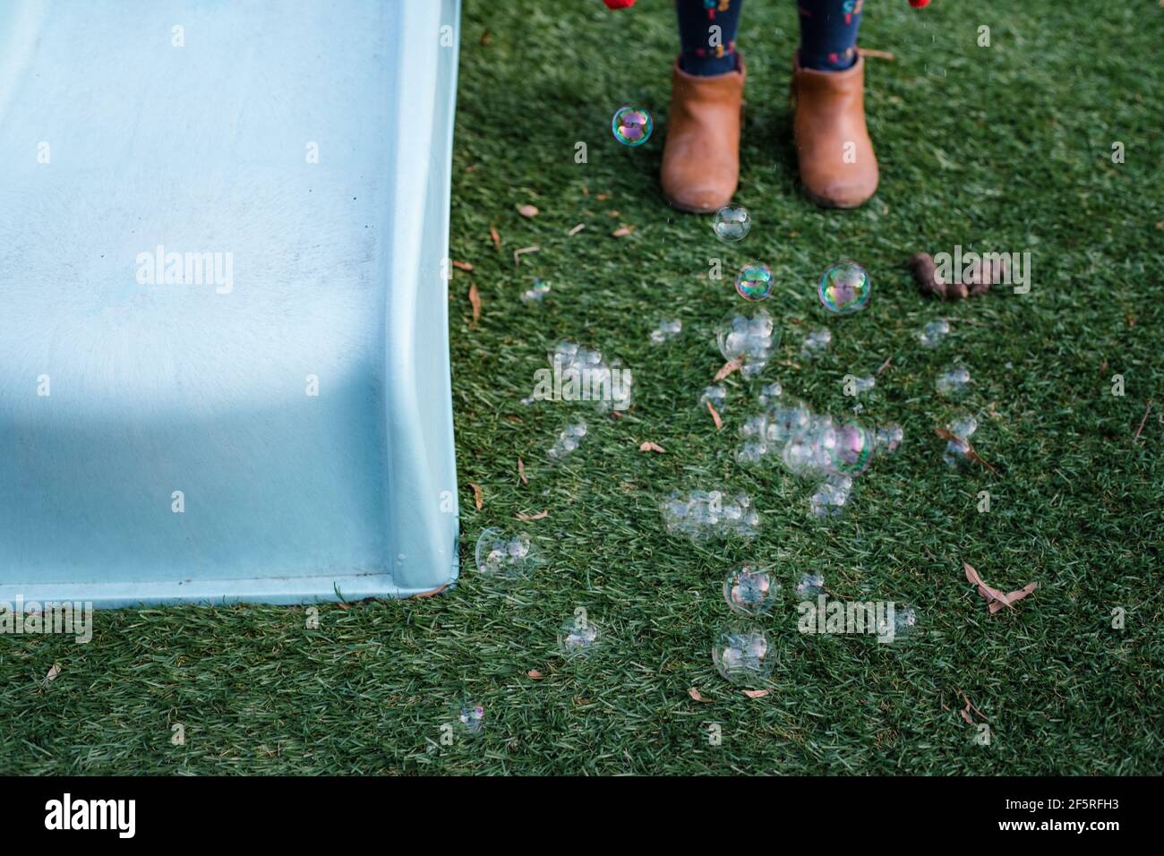 Mädchen in Stiefeln stehen neben Blasen auf dem Boden Stockfoto