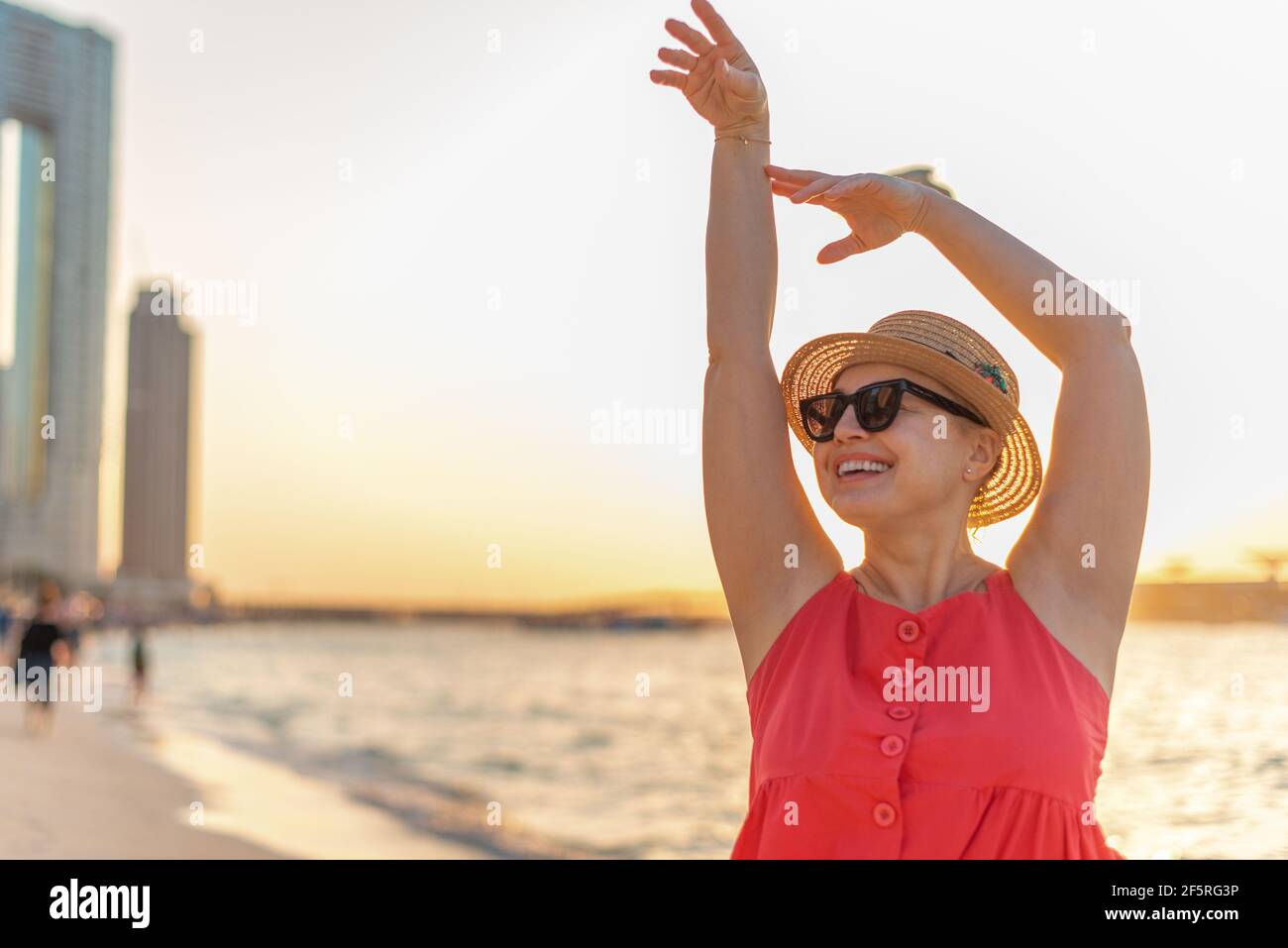 Attraktive Frau schaut beiseite mit den Händen hoch und schönen Sonnenuntergang Anzeigen Stockfoto