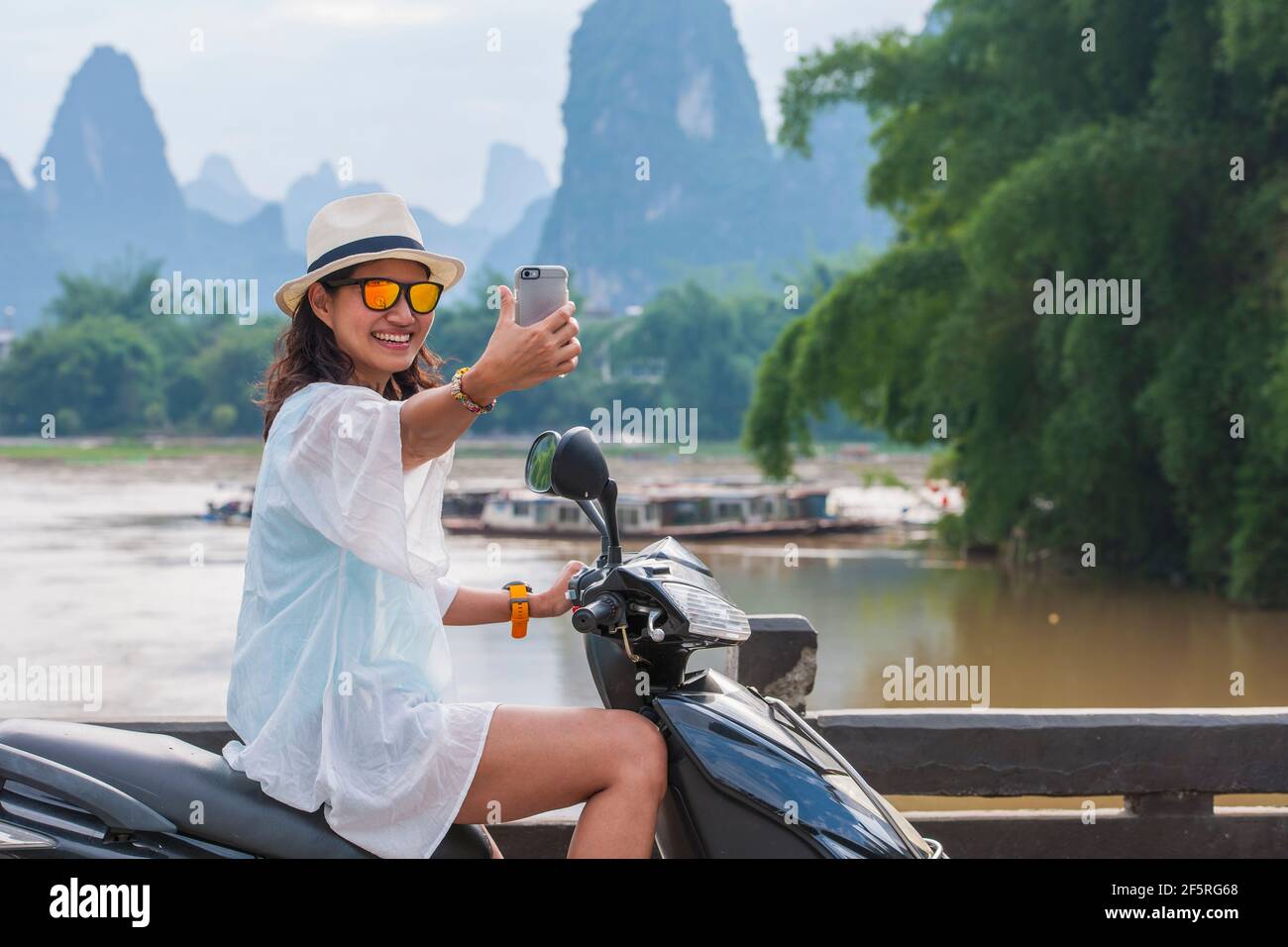 Frau, die Selfie nimmt, während sie die Landschaft um Yangshuo erkundet Stockfoto