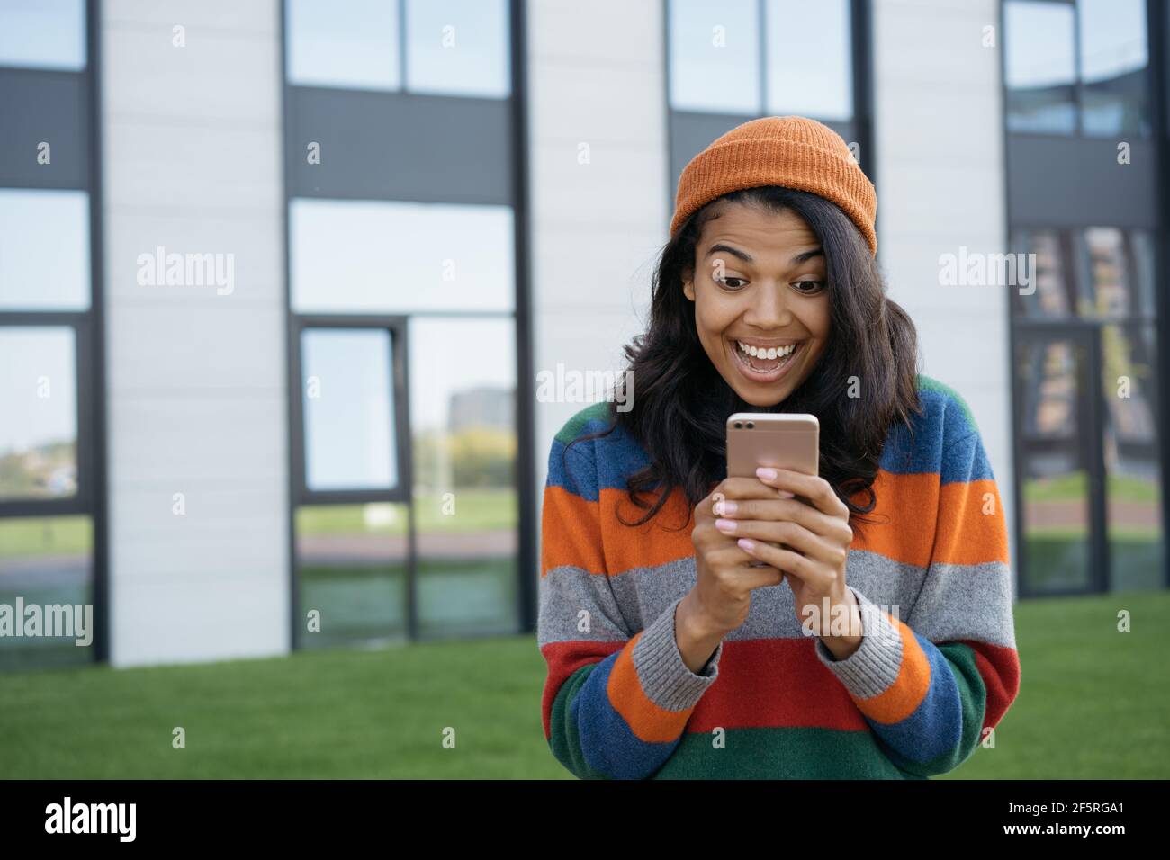 Aufgeregt afroamerikanischen Mann mit Handy, Online-Shopping. Portrait von überglücklich online Lotterie Gewinner Blick auf digitalen Bildschirm Stockfoto