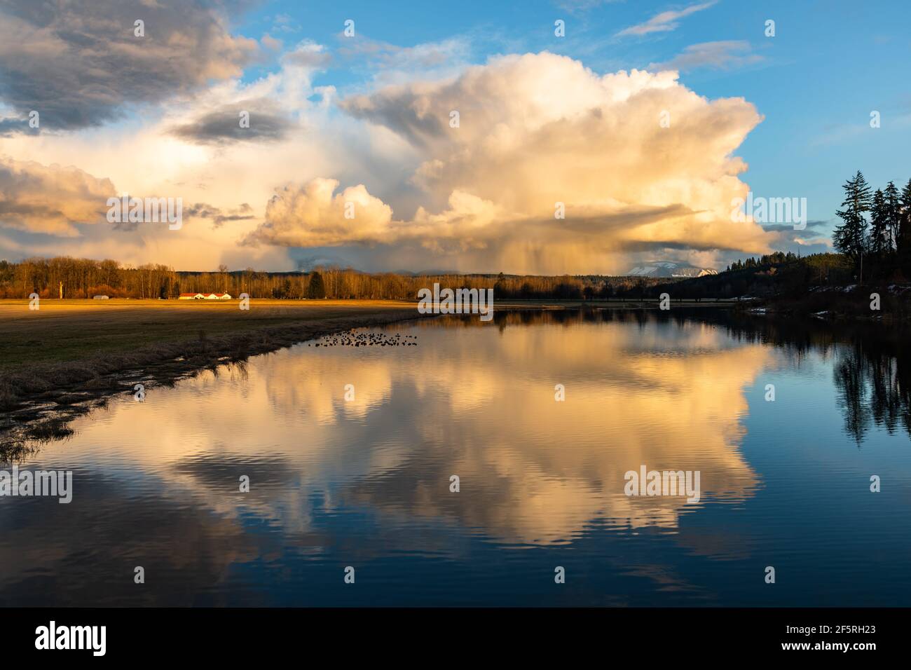 Ein Gewitter passiert das Snoqualmie Valley im Bundesstaat Washington und spiegelt sich in Sikes Lake in Carnation wider Stockfoto