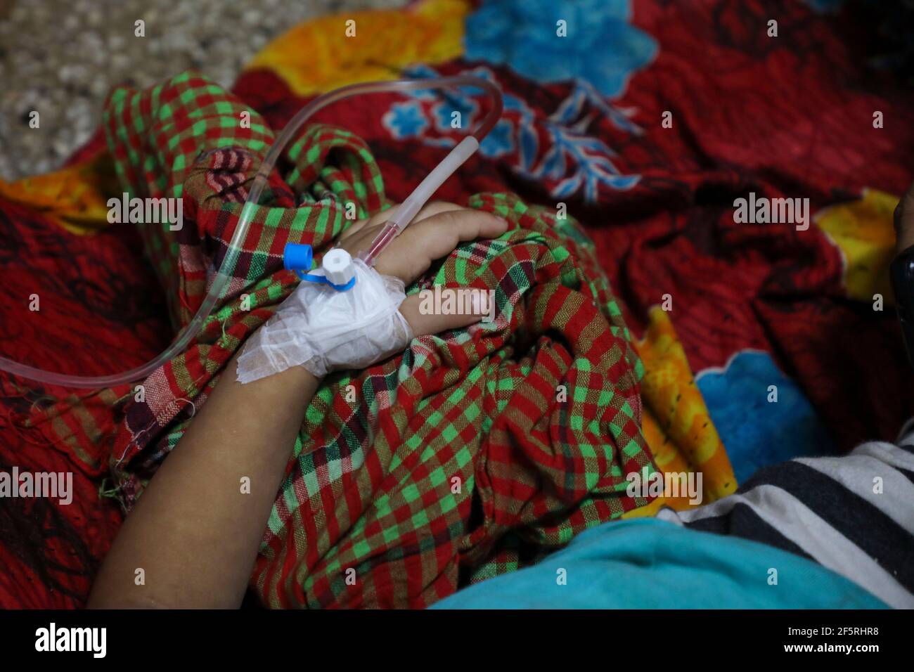 Eine Hand mit einer Kanüle eines Kinderpatienten mit¬ Moskito-übertragenem viralem Dengue-Fieber in einem Krankenhaus in Dhaka, Bangladesch Stockfoto