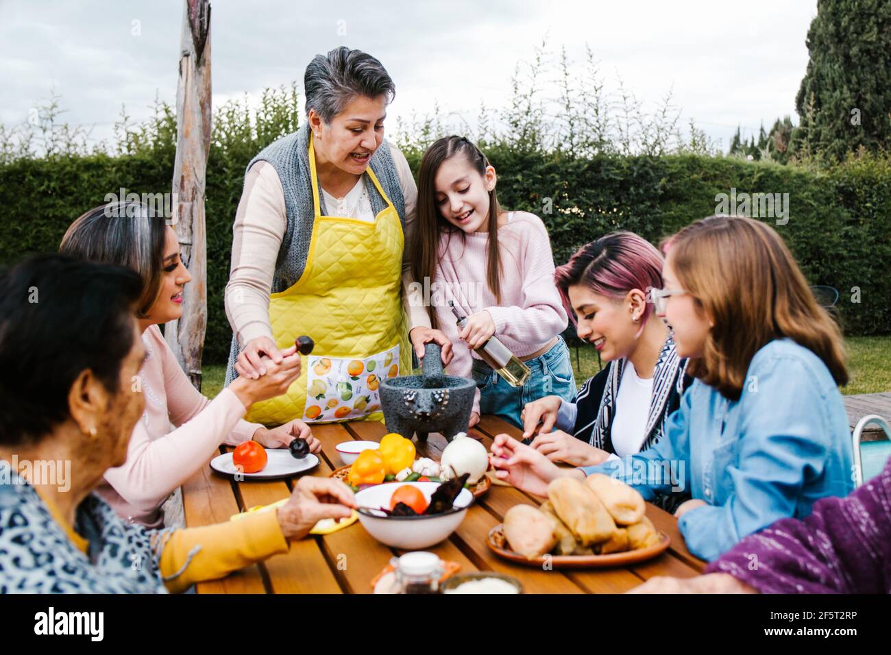 lateinische Großmutter und Enkelin, Tochter, die zu Hause mexikanisches Essen kocht, drei Generationen von Frauen in Mexiko Stockfoto