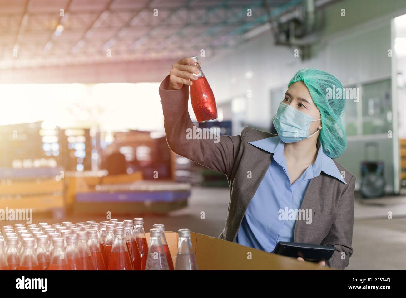 Qualitätskontrolle Inspektor Person arbeitet in der Getränkfabrik stichprobenartig zu überprüfen verunreinigen die Endprodukte. Stockfoto