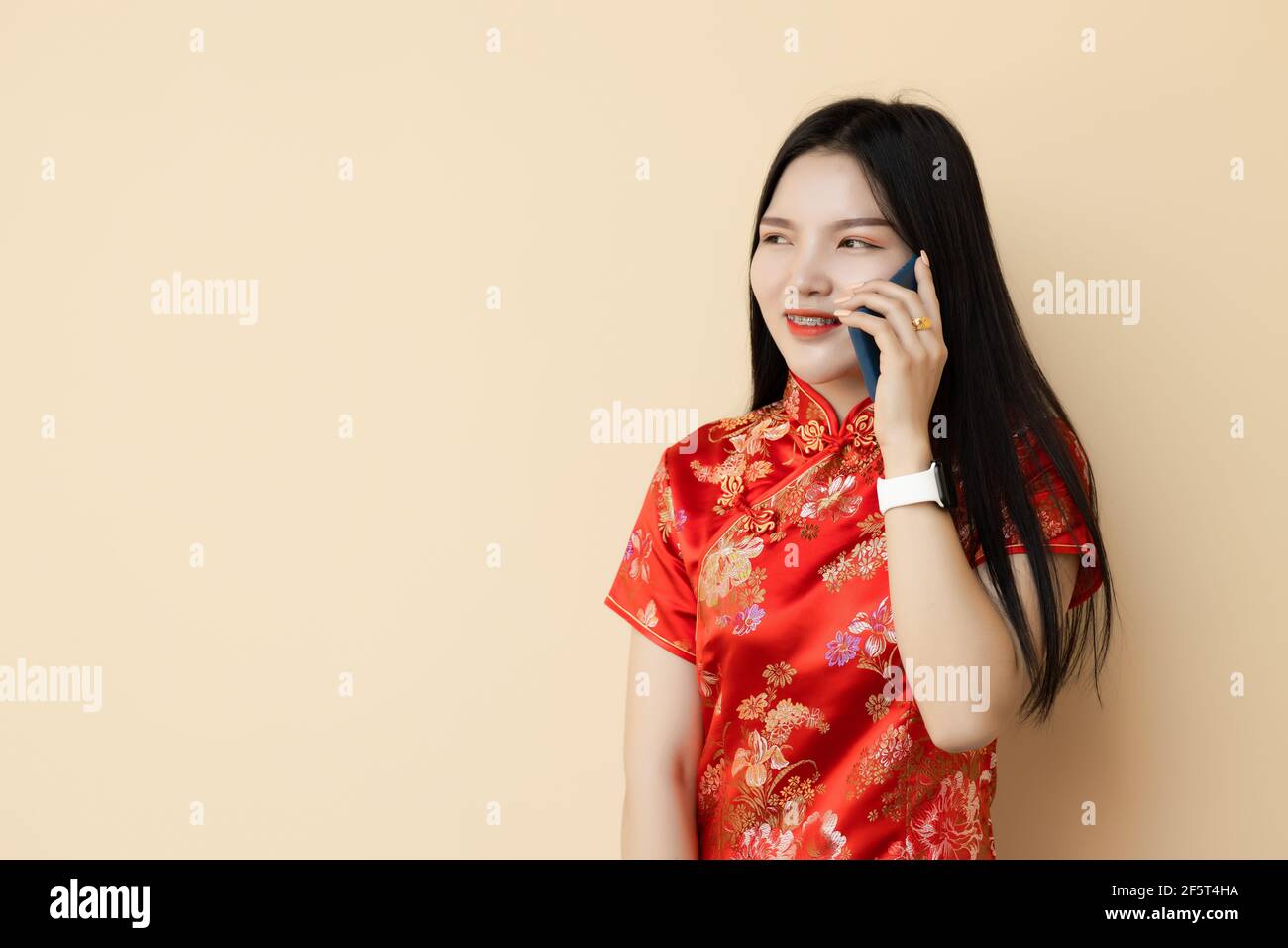 Chinesisch teen Mädchen telefonieren mit Freund Dressing Qipao traditionellen Tuch. Stockfoto