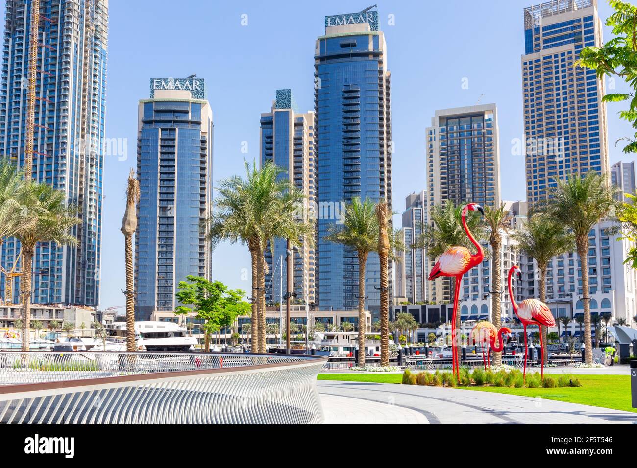 Dubai, VAE, 22,02.2021. Dubai Creek Hafenpromenade und Skyline mit Palmen und großen Flamingos-Skulpturen. Stockfoto