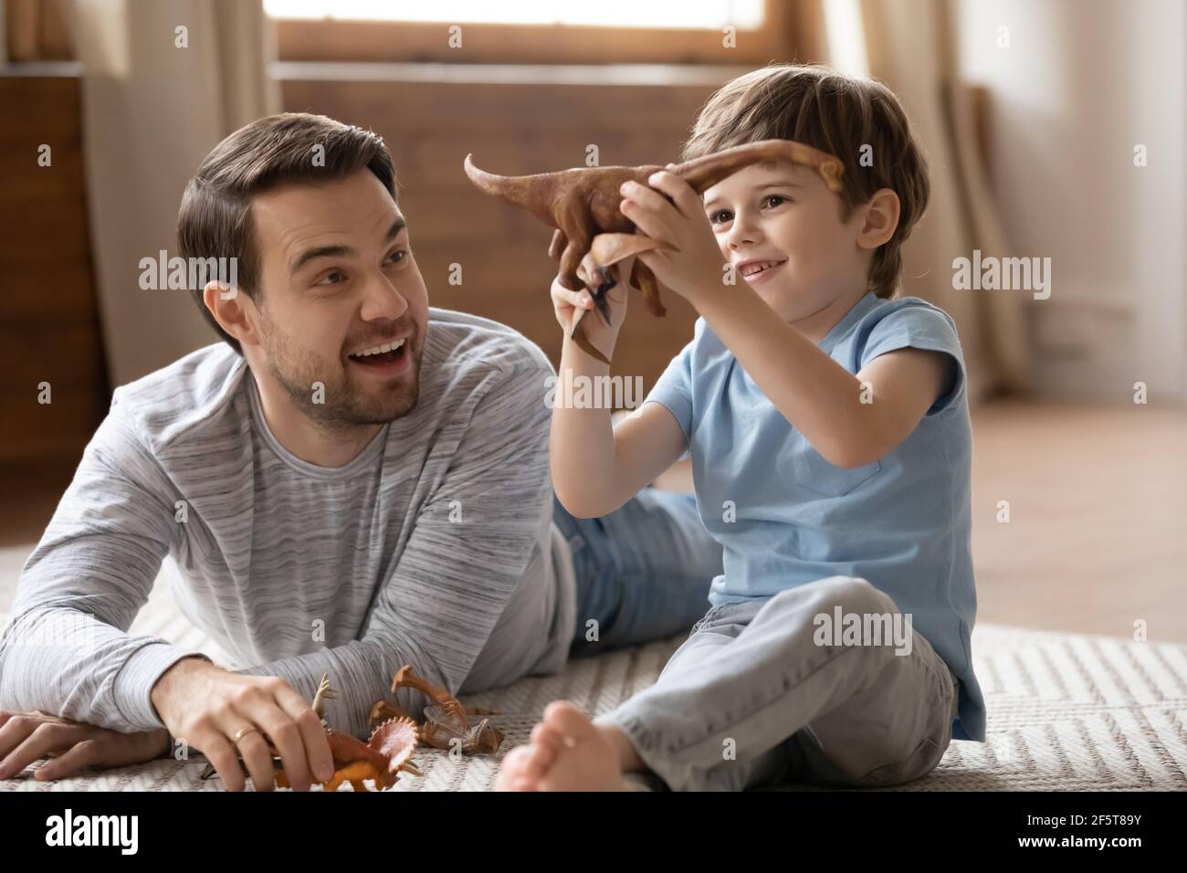 Aufgeregt Papa spielen mit Spielzeug mit kleinen Sohn Stockfoto