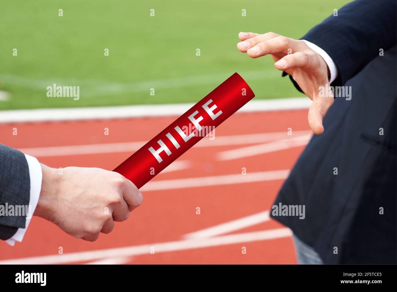 Geschäftsleute übergeben Hilfe Staffellauf in der deutschen Hilfe stadion Stockfoto