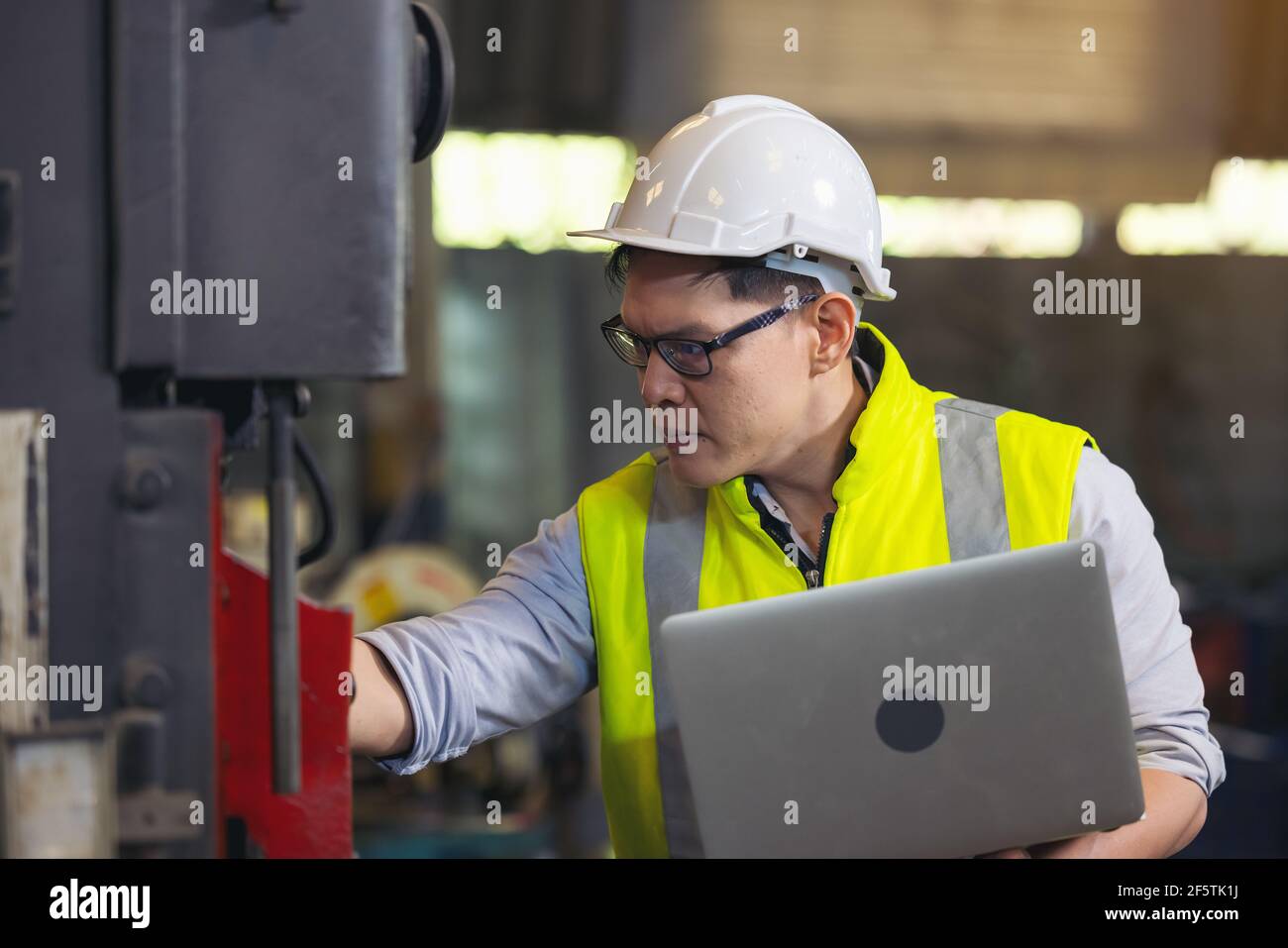 Techniker oder Techniker, die eine OP-Maske tragen und Computer-Notebook zur Überprüfung verwenden Stockfoto
