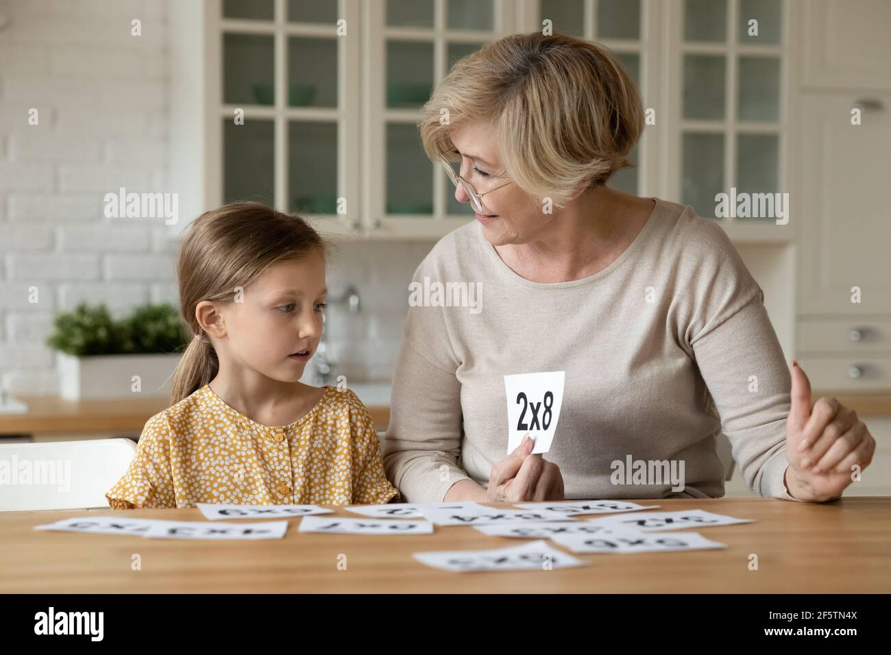 Ältere Großmutter lernen Mathe mit kleinen Enkelin Stockfoto