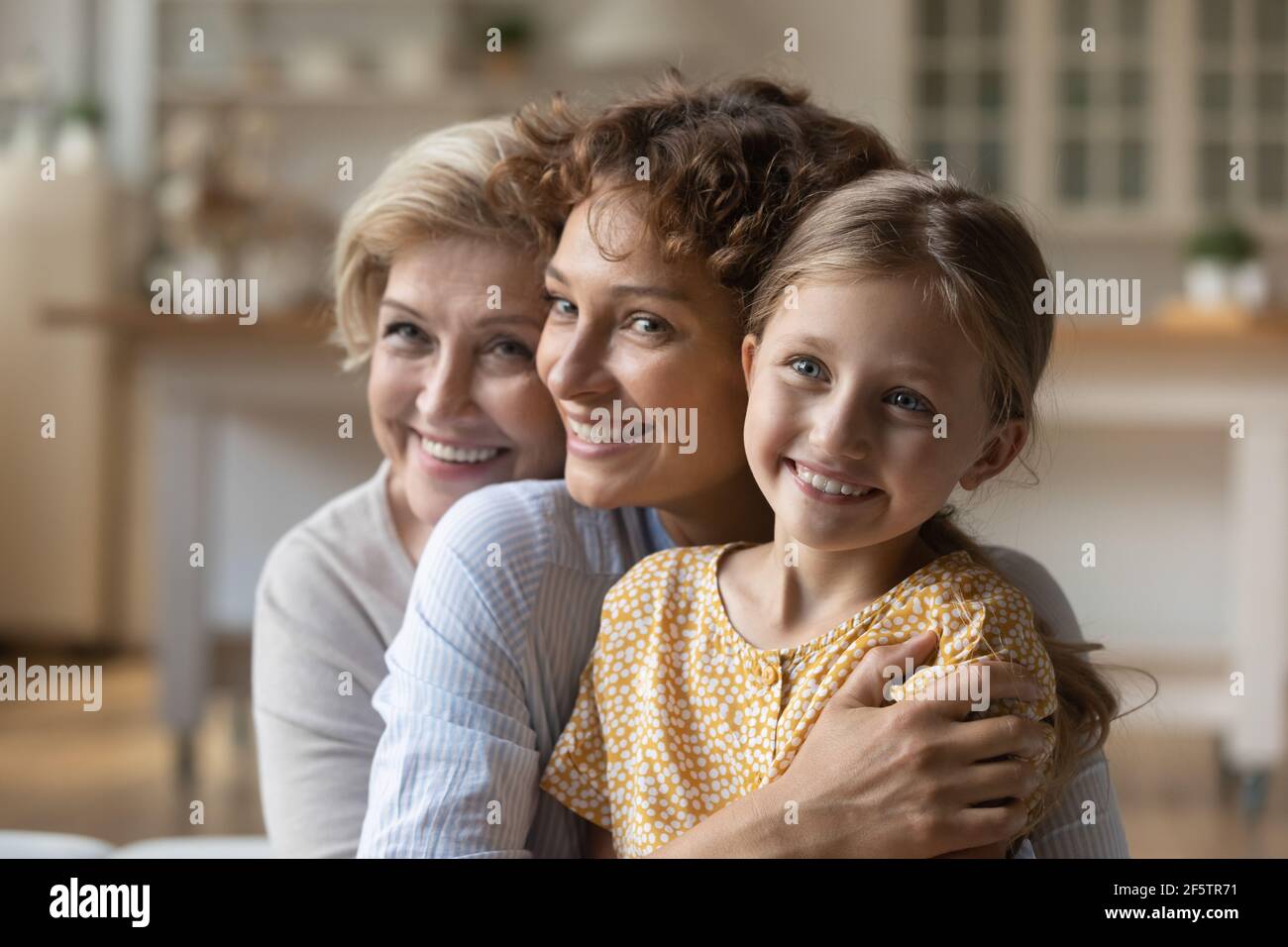 Glückliche drei Generationen von Frauen umarmen Kuscheln Stockfoto