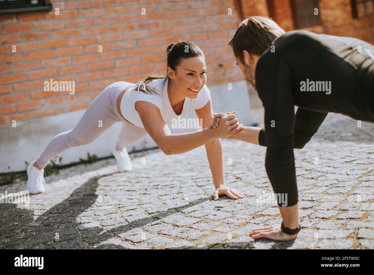 Gut aussehend junges Paar doung ein Arm Push-up Übung in die Städtische Umwelt Stockfoto