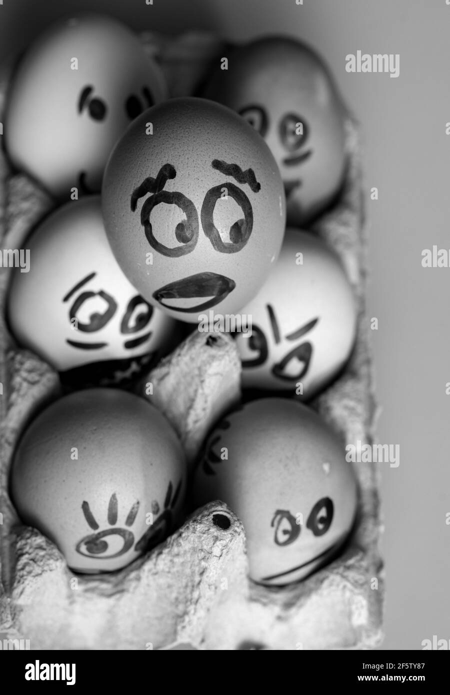 Verrückte Eier verängstigt. Verängstigte Gesichter, die aus dem Eiertablett spähen Lustige Ostergeschichten. Stockfoto