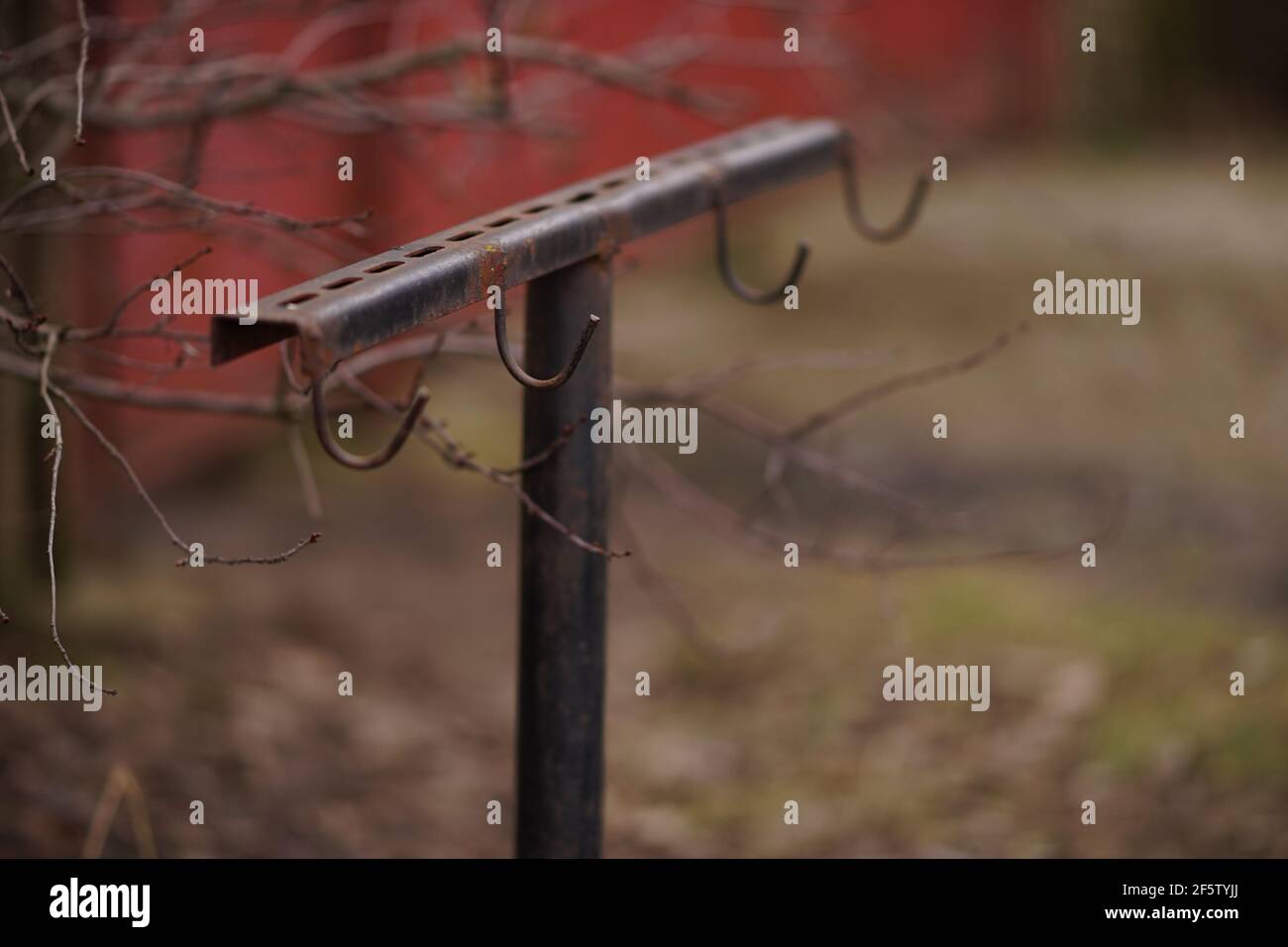 Eisenkeimer mit Haken steht ohne Eimer im Herbstgarten. Stockfoto