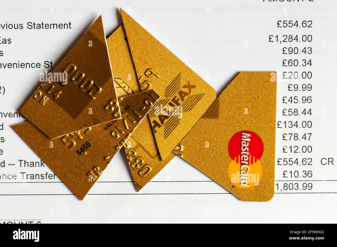 Kreditkartenabrechnung mit aufgeschnittener Karte, entweder um Schulden zu vermeiden oder Identitätsdiebstahl zu verhindern. Stockfoto