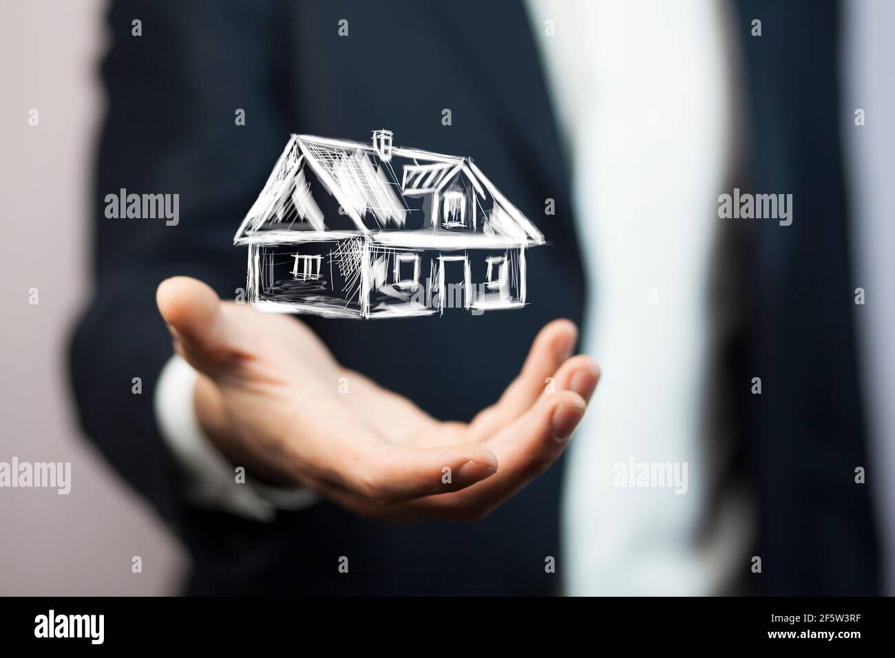 Immobilienangebot. Geschäftsmann hält ein künstliches Modell des Hauses Stockfoto