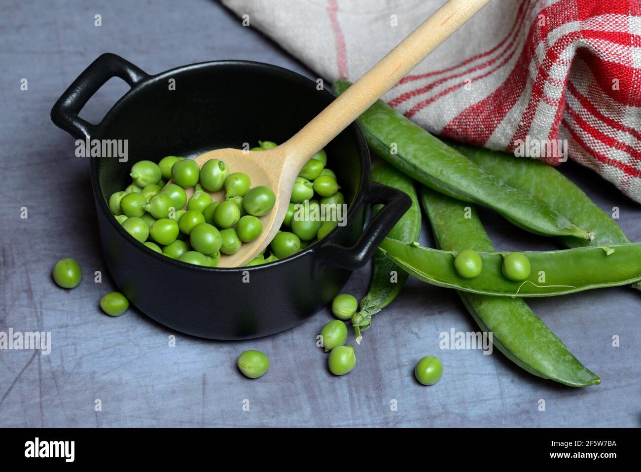 Grüne Erbsen in Töpfen und Kochlöffel, Erbsenschoten, Pisum sativum, Deutschland Stockfoto