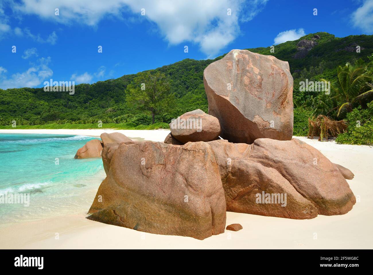 Anse Cocos Strand mit großen Granitsteinen auf La Digue Island, Indischer Ozean, Seychellen. Tropische Landschaft mit sonnigem Himmel. Exotisches Reiseziel. Stockfoto
