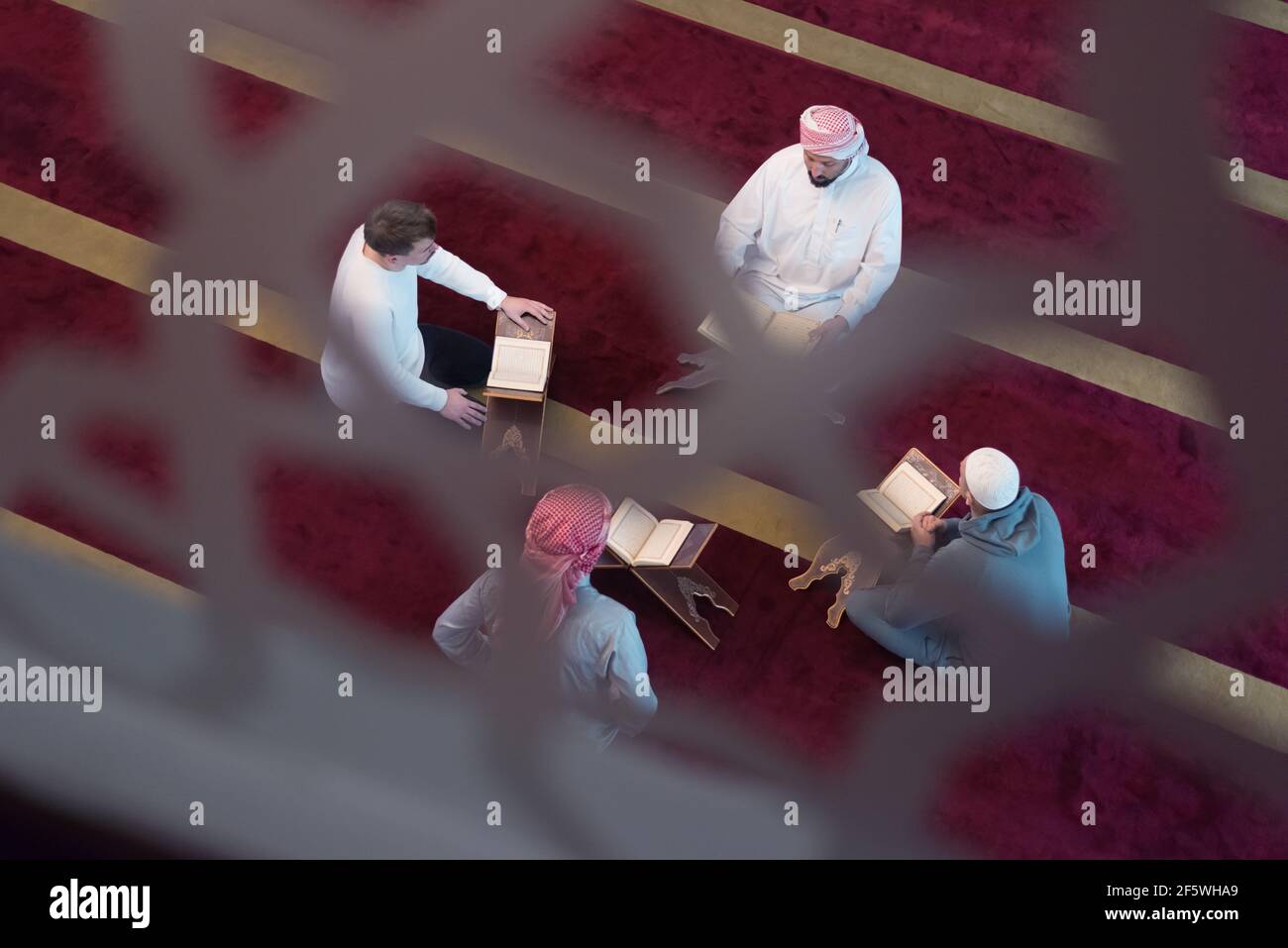 Gruppe von Muslimen beim Lesen, Rezitieren und erinnern Koran während der Ramadaninside moderne und neue Moschee Stockfoto