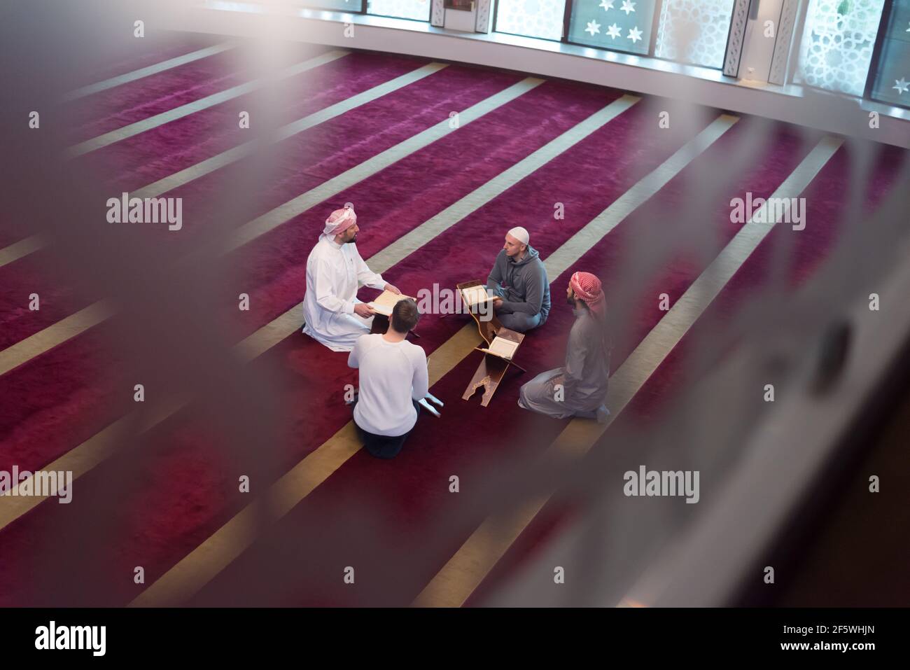 Gruppe von Muslimen beim Lesen, Rezitieren und erinnern Koran während der Ramadaninside moderne und neue Moschee Stockfoto