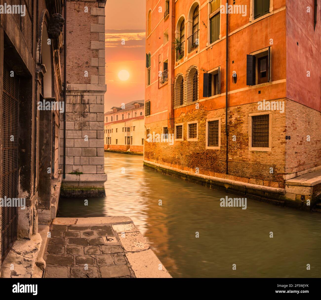 Untergehende Sonne in einem Seitenkanal im geheimen Venedig, Italien. Stockfoto