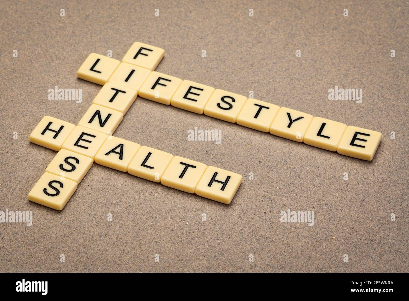 Fitness, Lifestyle und Gesundheit Kreuzworträtsel in Elfenbein Buchstaben Fliesen gegen strukturierte handgemachte Papier Stockfoto