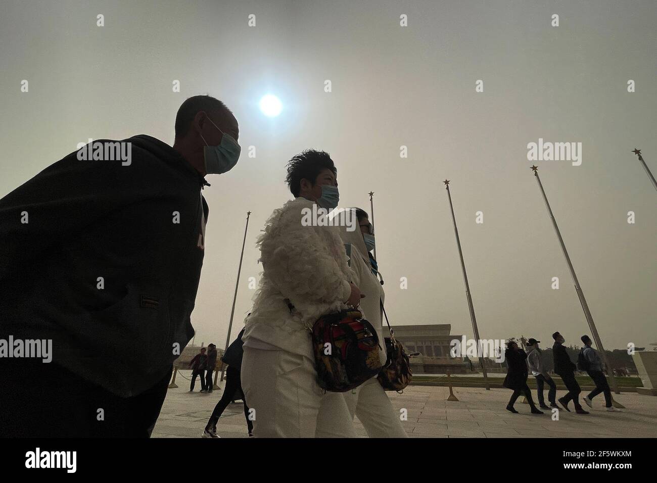 Peking, China. März 2021, 28th. Menschen tragen Masken, um Tiananmen malerischen Ort in Peking zu besuchen, umgeben von Sandstürmen. Die Sonne ist blau durch Staubstürme.EIN dichter Dunst steigt auf Peking herab, als ein Sandsturm die Stadt bedeckt. Chinas nationales Observatorium gab einen gelben Alarm für Sandstürme im nördlichen Teil des Landes. (Foto von Sheldon Cooper/SOPA Images/Sipa USA) Quelle: SIPA USA/Alamy Live News Stockfoto