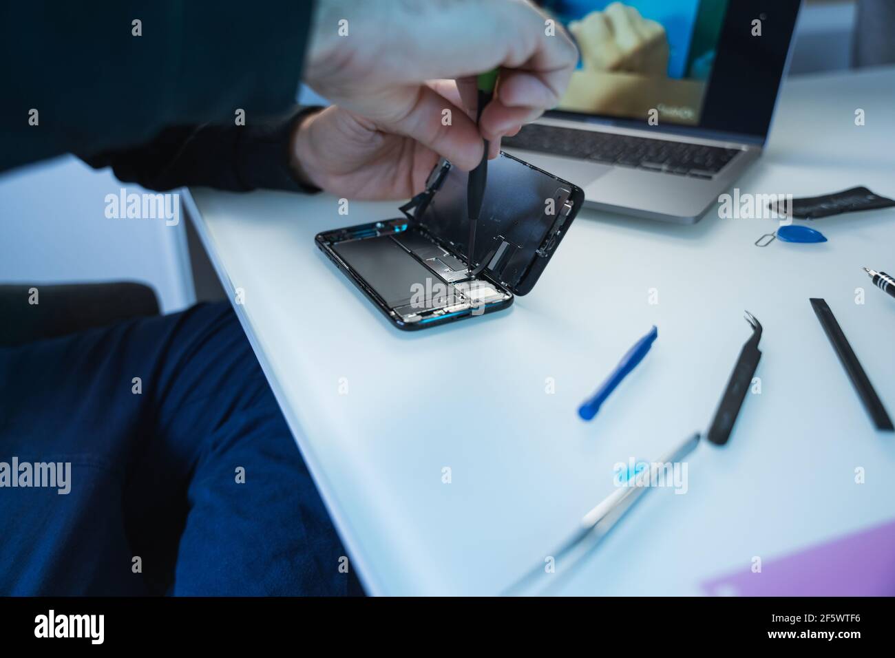 Techniker oder Techniker, der die Reparatur und den Austausch des neuen Smartphones vorbereitet Batterie wird am Schreibtisch vorbereitet Stockfoto