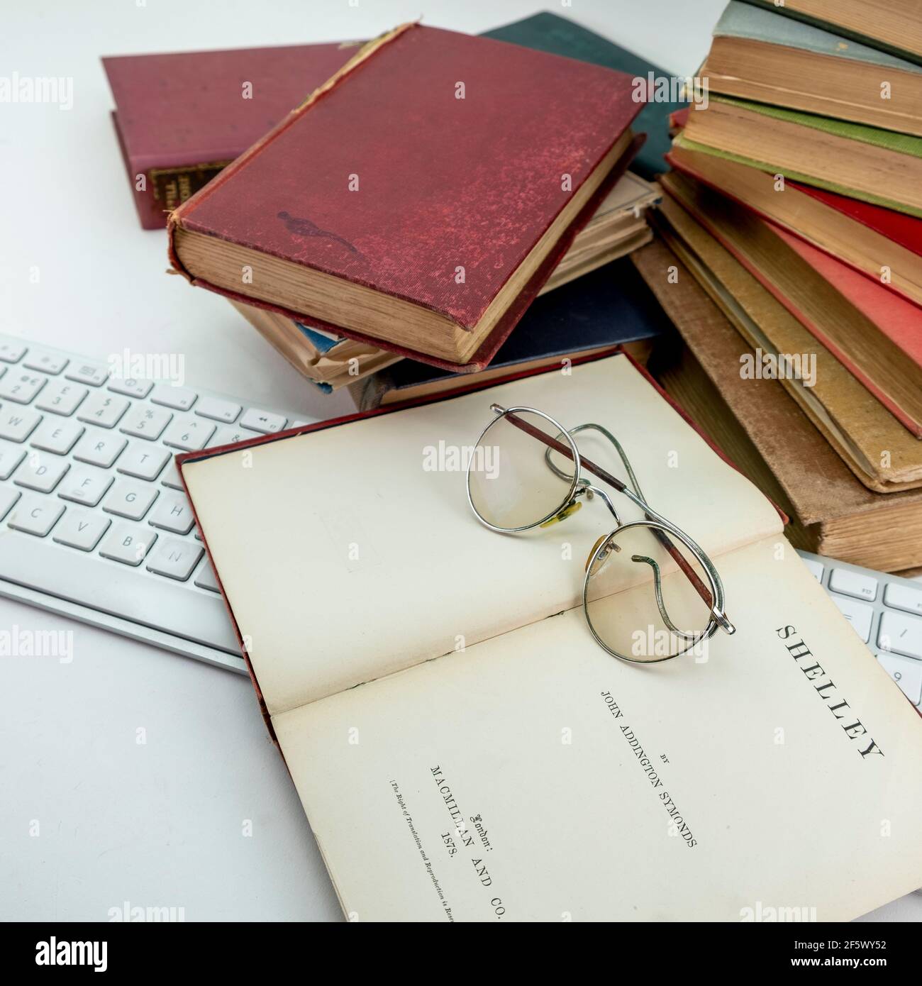 Seltene alte Vintage-Bücher aus der Bibliothek Shelley Gedichte, oben auf einer alten Brille auf weißem Hintergrund Stockfoto