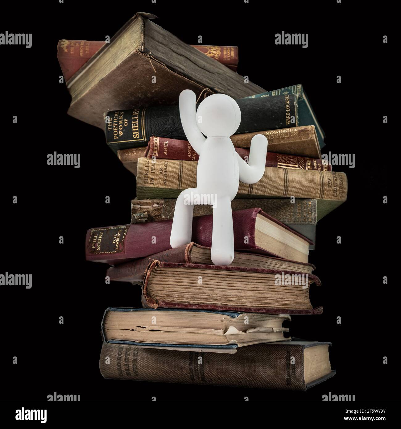 Weiße Statue klettert hinter der Bühne auf alte englische seltene Vintage-Bücher Weißer Hintergrund Stockfoto