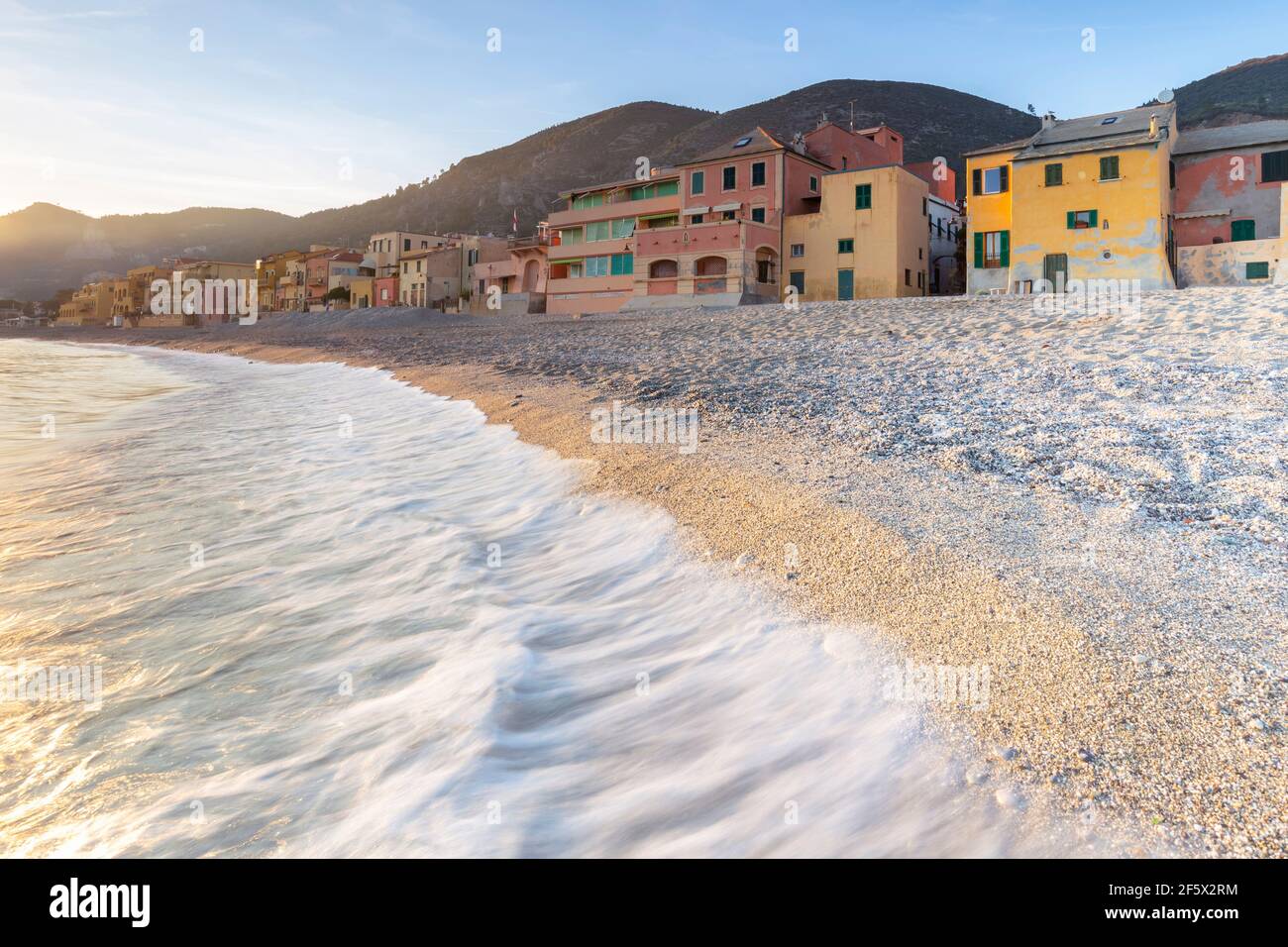 Nebliger Sonnenuntergang über den bunten Häusern und dem Strand von Varigotti, Finale Ligure, Bezirk Savona, Ponente Riviera, Ligurien, Italien. Stockfoto