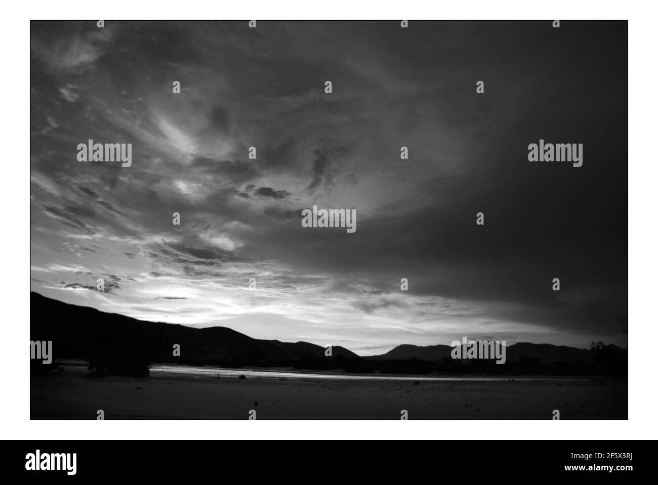 Unabhängiger Weihnachtsappellan...... Integrierte ländliche Entwicklung und Naturschutz (IRDNC) in Namibia.die trockene Wüstenlandschaft Namibias wartet auf die ersten Regenfälle der Saison. Ein klarer, bakeing blauer Himmel wird langsam in ein tiefes dunkelgrau gekocht, während die Wolken in Rollen. Der Regen stürmt und sobald knochentrockene Flüsse zum Leben erwacht. Foto von David Sandison November 2004 Stockfoto